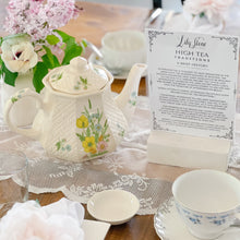 Load image into Gallery viewer, Tea party setup with floral teapot, cups, and a card on a wooden table.
