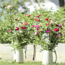 Load image into Gallery viewer, Bouquets of flowers in white vases on a grassy area with trees in the background