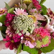 Load image into Gallery viewer, Bouquet of colorful flowers held by a hand against a white wooden background