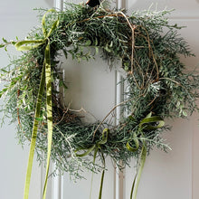 Load image into Gallery viewer, Green wreath with ribbons on a white door
